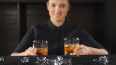 Kavram içme. Kokteyl yapma kavramı. Tanınmayan kadın barmen koyarak alkol içecek ile bar counter camlı. Ağır çekim. HD