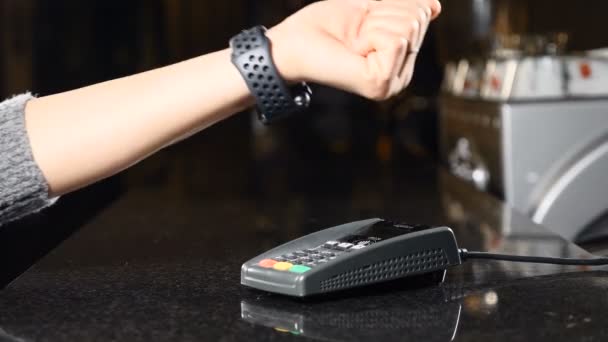 Modern payment concept. Closeup shot of Customer paying with NFC technology by smart watch on hand contactless on terminal in a cafe. Using the Terminal and the Smart Watch to pay the bill. 4k — Stock Video