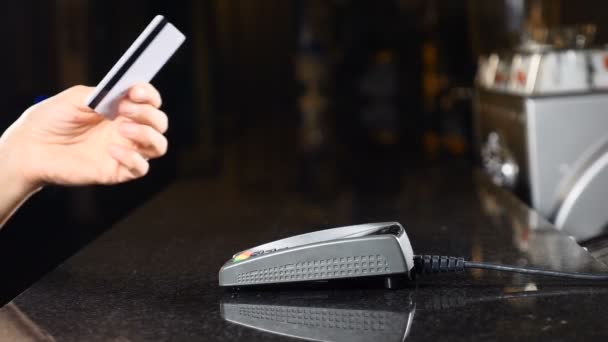 Modern way to pay money. Concept of contactless payment. Making payment with credit card and pos terminal. Female customer holding plastic credit card near payment terminal. 4 k — Stock Video