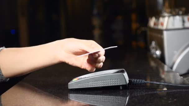 Modern way to pay money. Concept of contactless payment. Making payment with credit card and pos terminal. Female customer holding plastic credit card near payment terminal. 4 k — Stock Video