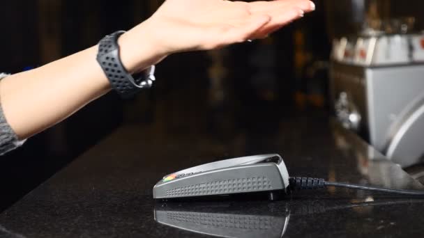 Modern payment concept. Closeup shot of Customer paying with NFC technology by smart watch on hand contactless on terminal in a cafe. Using the Terminal and the Smart Watch to pay the bill. 4k — Stock Video