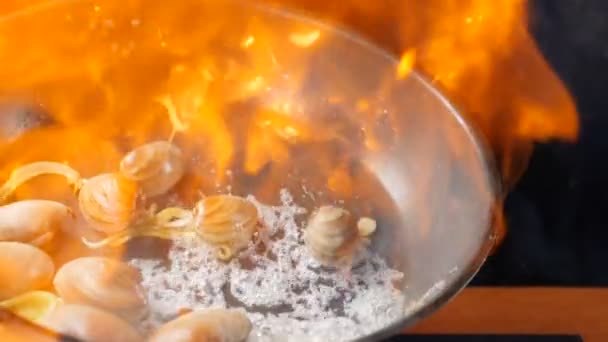 Restaurant Essen Kochen. Koch Kochen italienische Meeresfrüchte Pasta Flamme mit Garnelen, Venusmuscheln, Muscheln in Gericht. Konzept der italienischen Küche. Zeitlupe — Stockvideo