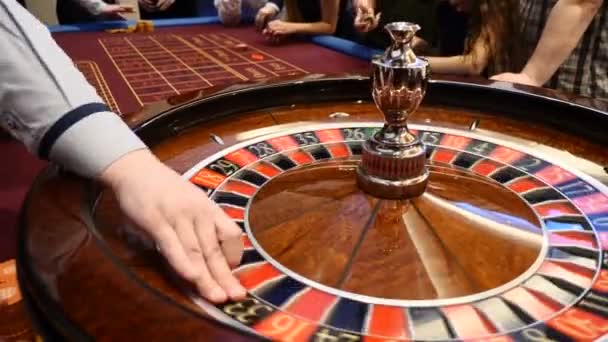 Nahaufnahme von Casino Roulette, das sich dreht und in der Nähe stapelweise Casino-Chips platziert. Hände von Menschen, die Karten und Chips in der Hand halten, Menschen, die spielen. Casino-Konzept. Die Händlerhand bewegt die — Stockvideo