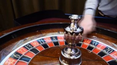 Casino tema. Üstten görünüm rulet hareket, beyaz topu iplik üzerinde. Kötü şans ve iyi şanslar kavramı. Rulet tekerleği çalıştıran. Şehir gece hayatı eğlence. Satıcı el rulet taşır. HD