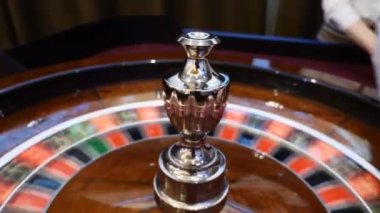 Casino tema. Üstten görünüm rulet hareket, beyaz topu iplik üzerinde. Kötü şans ve iyi şanslar kavramı. Rulet tekerleği çalıştıran. Şehir gece hayatı eğlence. Satıcı el rulet taşır. HD