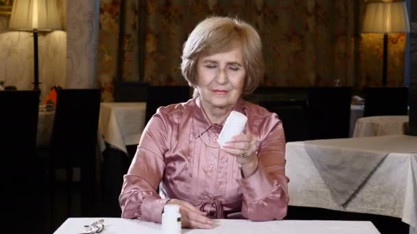 Egy idős nő nézett orvostudomány kezében. Felnőtt élet fogalma. Kellemes megjelenésű vezető nő olvasás címkék. 4k — Stock videók