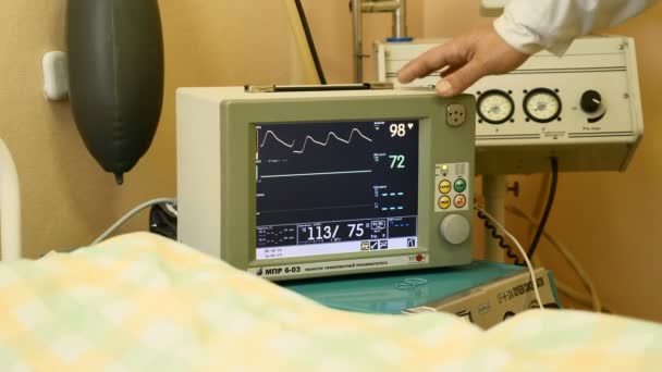 Helsebegrep. Smalt bilde av medisinsk utstyr på sykehusrommet. EKG. EKG. måling av puls. Doktoren har på seg en hvit frakk. Ugjenkjennelig pasient er på vakt. 4k – stockvideo