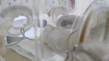 Mutlu annelik kavramı. Yeni doğmuş bir bebek kuluçka, yoğun hastane tedavisi: Ccu, yoğun bakım, İTÜ. kısa bebek fanila preterm bebek. Doktor closeup çekim ayarı tıbbi algılayıcılar yılında eller