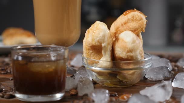 Bom dia, conceito. Croissants deliciosos em tigela de vidro e café latte em copo transparente. Conceito de cafetaria. hd — Vídeo de Stock
