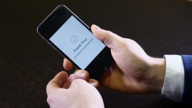 Modern bir akıllı telefon ödeme tebliğ üstünde perde. Temassız ödeme. Erkek el bir cep telefonu tutan closeup çekim. Teşekkür ederim uyarı görsel olduğunu. İş kavramı. HD