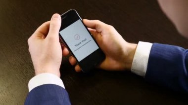 Modern bir akıllı telefon ödeme tebliğ üstünde perde. Temassız ödeme. Erkek el bir cep telefonu tutan closeup çekim. Teşekkür ederim uyarı görsel olduğunu. İş kavramı. HD