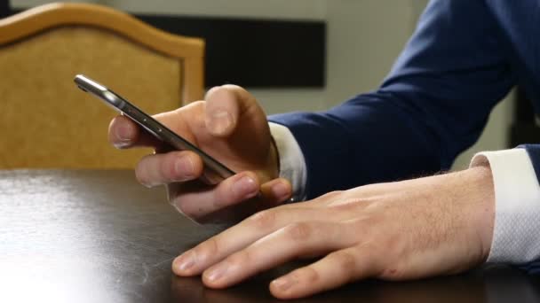 Ręce człowieka w garniturze gospodarstwa czarny smartphone. Mężczyzna palce dotykając ekranu telefonu komórkowego. Płatności bezstykowych. człowiek jest pisanie wiadomości sms, zbliżenie. naciśnięcie ekranu dotykowego, przesuwanie i przewijanie. HD — Wideo stockowe