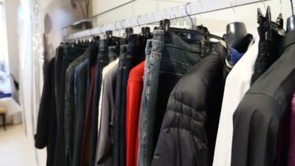 Au magasin de vêtements. Rangée de vêtements pour hommes et femmes. vestes, jeans et chemises sur cintres. Collection de nouveaux beaux vêtements accrochés à des cintres dans un magasin. Nouvelle collection dans la boutique de mode. Pas de peuple — Video