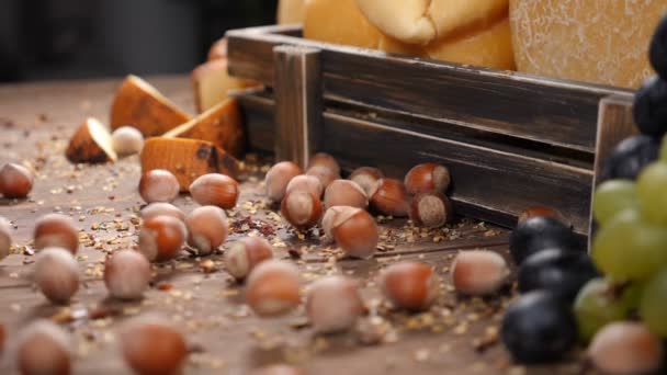 Arte de la comida. Nueces moviéndose en cámara lenta. Variedad de sheese colocada en caja de madera decorada con uvas. Restaurante de lujo que sirve comida. hd — Vídeos de Stock