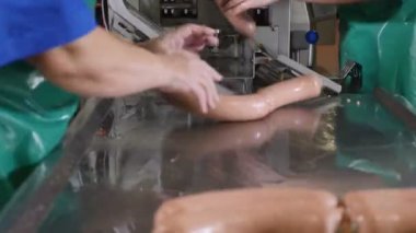 Kan ve et işleme tesisi. Erkek çalışma sosis üretim hattı eller. sosis conveor et fabrikasında son parçası. 4k