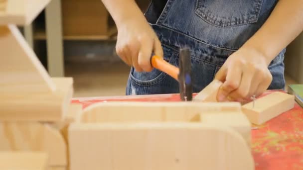 Kinder spielen in Bastelwerkstatt. niedlichen kleinen Jungen hämmern Nägel Nahaufnahme Schuss. Junge hilft seinem Vater im Haus. 4k — Stockvideo