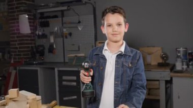 Küçük ana kavram. Ahşap tahta bir delik delme marangozluk sevimli çocuk portresi. HD