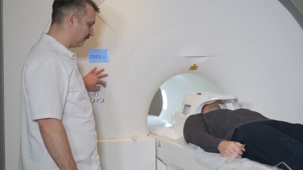 Pacient se pohybuje do Ct skeneru. Zdravotnické zařízení: počítačová tomografie stroj v novotvarů. Koncepce zdraví. Lékař stiskne tlačítko nastavení Ct Mri skeneru. HD — Stock video