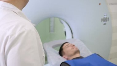 Erkek hasta Ct tarayıcı hareket ediyor. Tıbbi ekipman: tanı klinik bilgisayarlı tomografi makinede. Sağlık kavramı. Doktor presler koyma düğme Ct Mr'ı inceden inceye gözden geçirmek.
