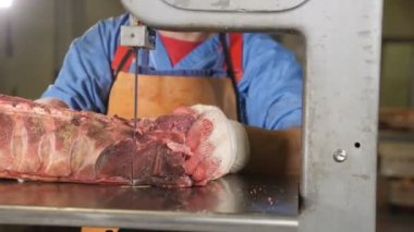 Et işleme fabrikası. Et testere closeup çekim. Fabrika modern ekipman. Et fabrikası. Adam işçi kesim çiğ et çelik bandında makinesi gördüm. 4k