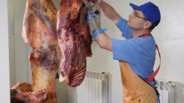 Kasap kesimi, taze et işleme. Et işleme tesisi. Sosis endüstrisi. Elinde keskin bir bıçakla eti kemikten ayıran bir et adam resmi. 4k