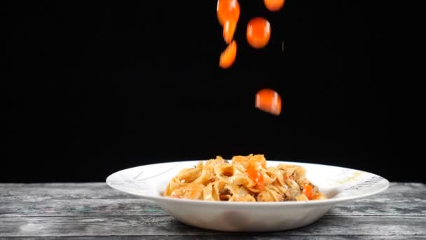 Cocinar en cámara lenta. Tomates cherry cayendo en plato con pasta diliciosa. Fotografía con cámara de alta velocidad.Concepto de cocina. hd — Vídeo de stock