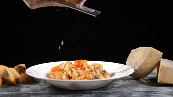 Kocken gallerdurk hårdost. Matlagning skaldjur pasta. Slow motion av cook rivjärn ost, typisk italiensk ost, pasta på plattan bara nylagad koncept: italiensk mat, ost, restaurang och mat — Stockvideo