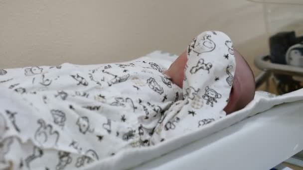 Концепция родильного дома. Неузнаваемый младенец готовится к медицинским процедурам. Вакцинация новорожденных. Детское здоровье. Маленькие ножки новорожденного ребенка. 4k — стоковое видео