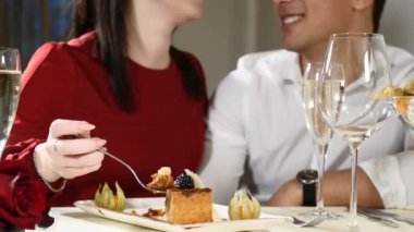 Romantik ve aşk maceraları. Genç çift bir tarih. Bir kadın erkeğini lezzetli bir tatlı ile beslenir. Çift bir restoranda gülüyor. Bir bardak şampanya masada. HD