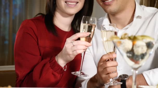 Ganska ung par på ett datum i restaurangen. Hålla glas champagne. Begreppet romantiska relationer. Dating koncept. HD — Stockvideo