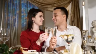 Genç çift kadeh şampanya içinde restoran. Dating. Genç adam ve Sevgililer günü kutlama kadına romantik akşam yemeği restoranda, içme. Romantik kavramı ve aşk maceraları. HD
