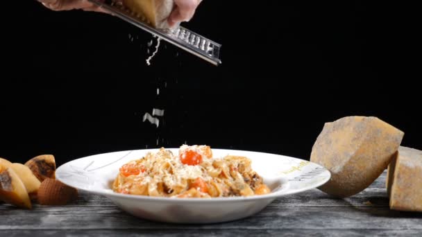 Chef rallando queso duro. Cocinar pasta de mariscos. Lento movimiento de un queso rallador cocinero, queso italiano típico, pasta en el plato recién cocinado Concepto: cocina italiana, queso, restaurante y comida — Vídeo de stock