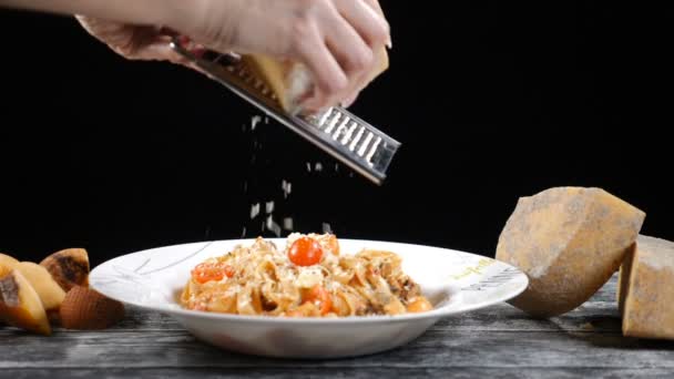 Chef grating hard cheese. Cooking seafood pasta. Slow motion of A cook grater cheese, typical Italian cheese, pasta on plate just freshly cooked Concept: Italian cuisine, cheese, restaurant and food — Stock Video