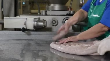 Bir uzun sosis gelen birçok kısa sosis şekillendirme et fabrikası işçisi. Sosis fabrikası işçileri sosis haşlama üretmek. Et işleme tesisi. Yakın çekim. Sosis üretim parçası. 4k