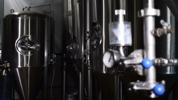 Zbiorniki magazynowe w browarze. Piwowarski fabryki w pomieszczeniu. Wnętrza fabryki piwa z beczki piwa i maszyn. Zbiorniki piwa w browarze. 4k — Wideo stockowe