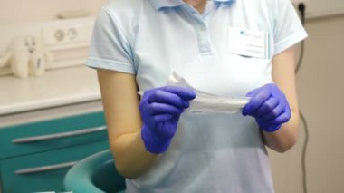 Eldiven steril ayna ve ölçekleyici araçları paketi açtığınızda kadın diş hekimi closeup çekim. Tıbbi Sınavı Hazırlık. Sağlık kavramı. 4k