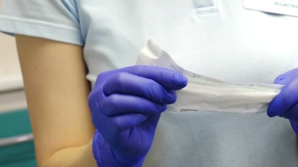 Zubní ošetření. Detailní záběr zubař asistent v rukavicích otevření balíčku s sterilní zrcadlo a čítače nástroji. Příprava na lékařské vyšetření. Zdravotnické koncepce. 4k — Stock video