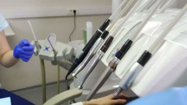Kadın diş hekimi araçlarını kullanarak, vakum, matkap, ekipman, diş Office Araçları yakın çekim shot. Diş hekimi el ile tıbbi alet alır. Sağlık Kliniği. 4k