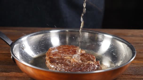 Profesionální kuchař vaří steak flambe. Cook sad oheň, aby maso na pánev, vaření s ohněm, opékání a grilování, požár v pomalém pohybu 180 snímků za sekundu. Zpomalený pohyb. HD — Stock video