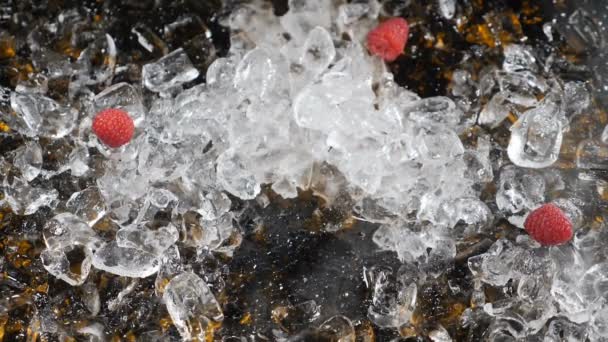 Bagas congeladas quebrando na mesa com cubos de gelo. Framboesa congelada em nitrogênio líquido quebrando em pedaços. Morango congelado esmaga em uma mesa. Cubos de gelo no fundo. Um movimento lento. Arte alimentar — Vídeo de Stock