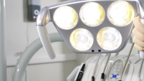 Kobiece ręczne dopasowanie stomatologiczne oświetlenie LED przed operacją, narzędzia dentystyczne i profesjonalny sprzęt dentystyczny przygotowuje się do użycia przez ortodontę. Kobieta stomatolog dostosowanie gabinetu stomatologicznego — Wideo stockowe