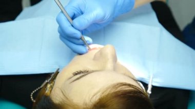 Kadın doktor Bayan hasta onu dolapta davranır. Diş ofiste genç kadın görüntüsünü kapatın. Diş hekimi kullanma ayna ve diğer enstrümanlar Kliniği. 4k