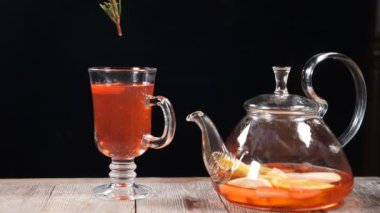 Son dokunuş kavramı. Barmen cam meyve çayı ile biberiye yaprağı koyar. Ağır çekim. HD