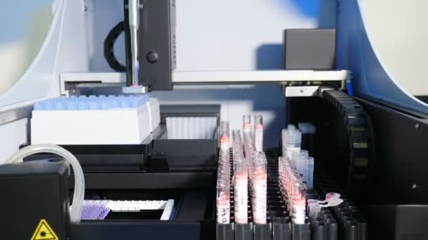 実験室の分析および診断機械。現代の医薬品製造工場で自動化されたコンベヤーに血が付いている容器または試験管が付いているロボティックマニピュレーターの腕。医療、ヘルスケア — ストック動画
