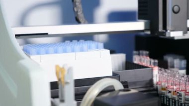 Modern ilaç üretim fabrikasında otomatik konveyör üzerinde kan ile konteyner veya test tüpleri ile robotik manipülatör kollar. Tıp, sağlık konsepti. Tıbbi analizör. Laboratuvar