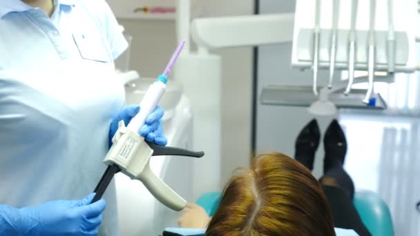 Tandheelkunde, geneeskunde, stomatologie concept. Tandheelkundige lijm apparaat. Close-up van een arts die tandheelkundige apparatuur in handen. technologie tandheelkundige proces. 4k — Stockvideo