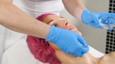 Deri kaldırma işlemi yapan kozmetolojiuzmanının yakın çekim çekimi. Güzellik kliniğindeki genç bir kadın. Spa terapisi. Anti-aging kavramı, Beautician kendi salonda. Hd
