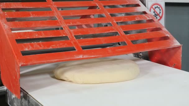 Commerciële bakkerij. Deeg rolmachine. Vrouw werkt bij restaurant Kitchen Rolling deeg door machine. Het maken van croissants en bakkerijproducten. Pasta maken in restaurant. 4k — Stockvideo