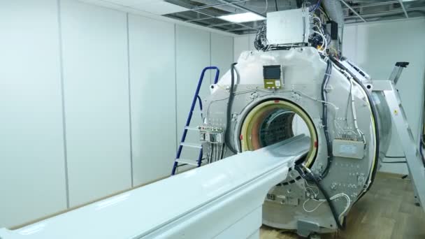 MRI-scanner zonder bovenste kunststof bekledings panelen. MRI machinemontage en installatie. Bouw van nieuw modern ziekenhuis met Mr-Imaging unit in de kamer. Lang schot. 4k — Stockvideo
