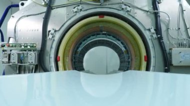 MRI tarayıcısı yükleniyor. Boş bir MRI, CT, PET tarayıcı. MRI tarayıcı tünelinin yakın çekim görüntüsü. Odada MR görüntüleme ünitesi olan yeni modern hastane binası. 4k